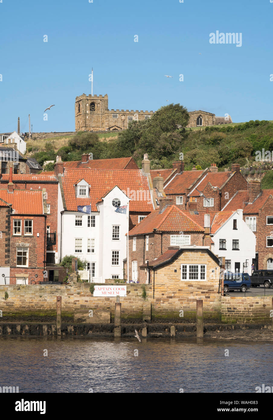 Il Captain Cook museum e chiesa di Santa Maria si vede attraverso il fiume Esk a Whitby, North Yorkshire, Inghilterra, Regno Unito Foto Stock