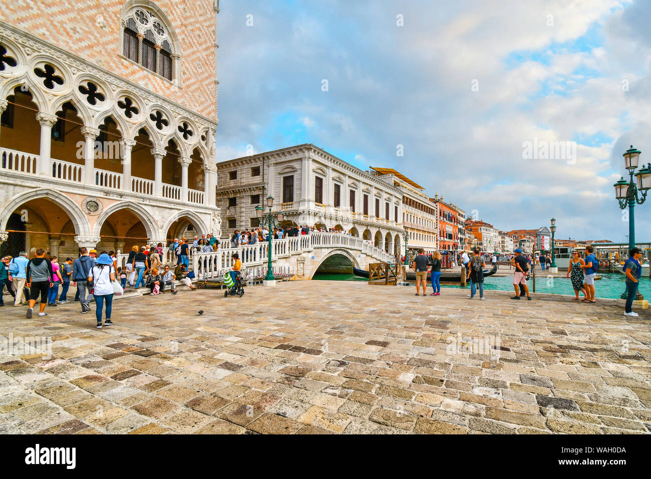 I turisti attraversare la Riva degli Schiavoni ponte mediante il Palazzo Ducale, Palazzo Ducale e Piazza San Marco a Venezia, Italia Foto Stock