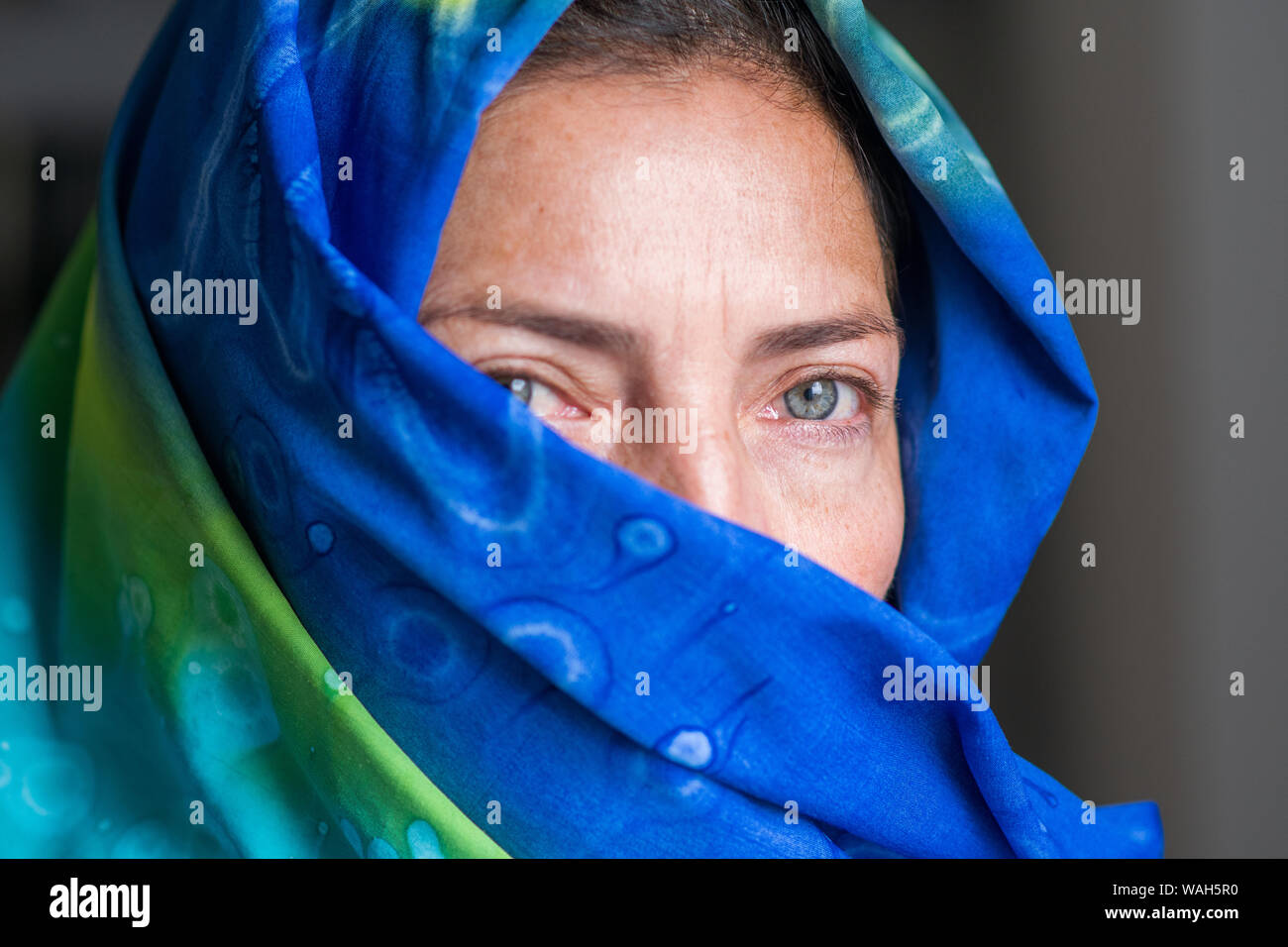 Verde pallido occhi ritratto di donna che indossa un colorato burka Foto Stock