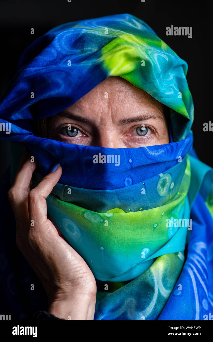 Ritratto di un verde pallido occhi donna che indossa una sciarpa colorata Foto Stock