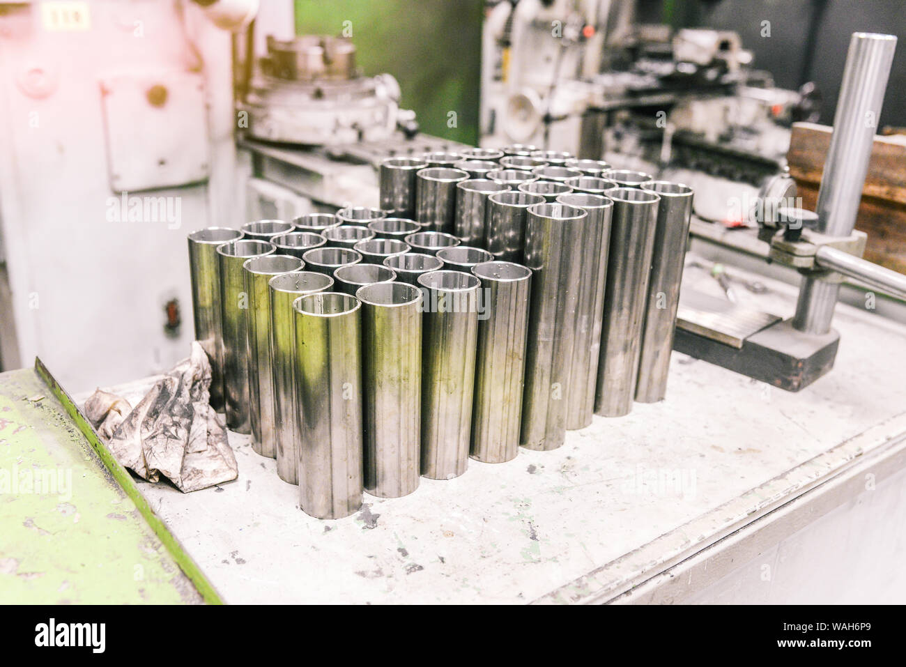 Tubi in acciaio di varie forme nell'industria metallurgica. Le parti cromate prodotte in fabbrica. Dirty rag e macchina. Il posto di lavoro di un empl Foto Stock