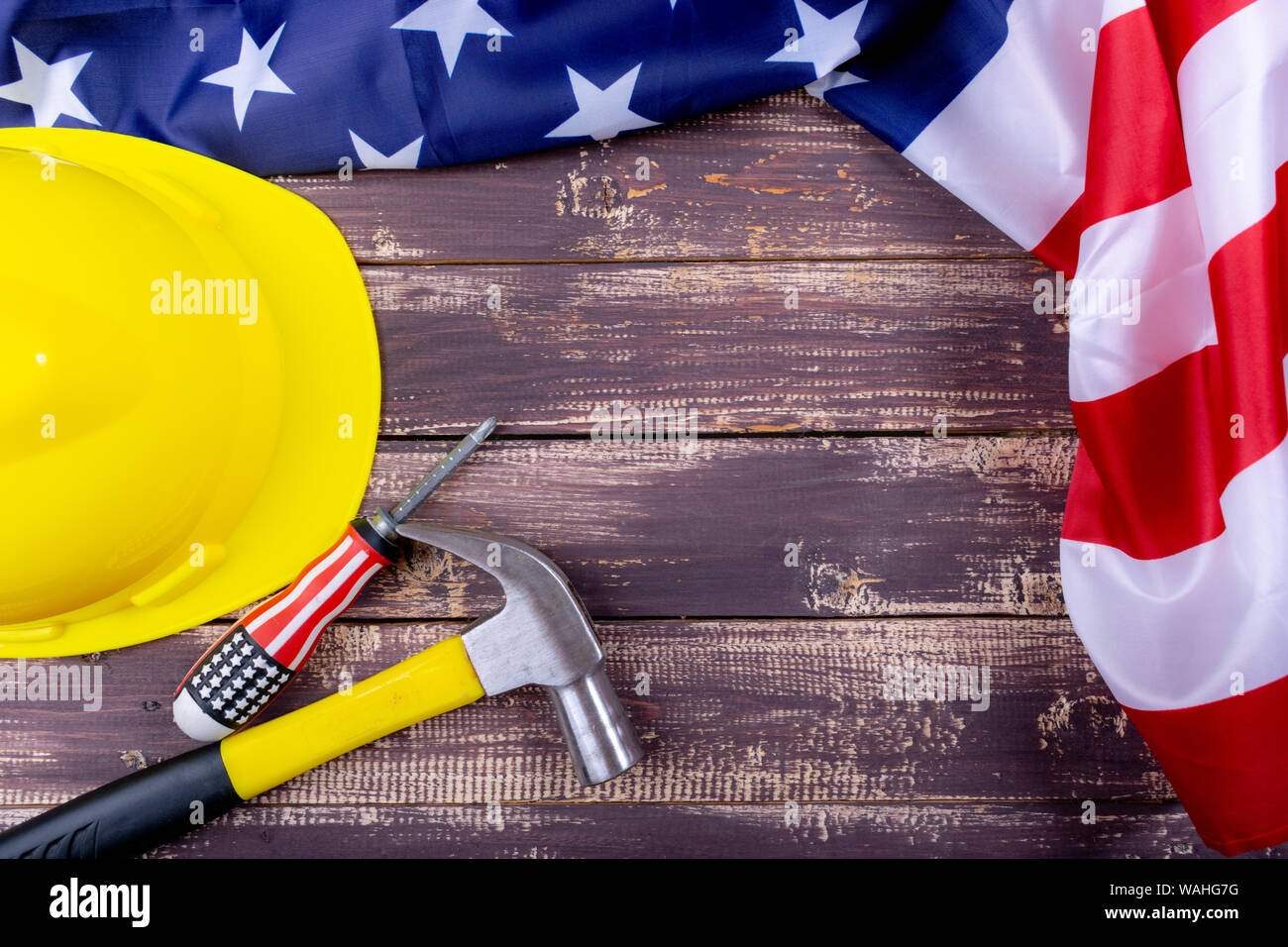 La giornata del lavoro USA concetto, Set di vari strumenti su sfondo di legno con bandiera USA. Copia spazio per il testo. Foto Stock