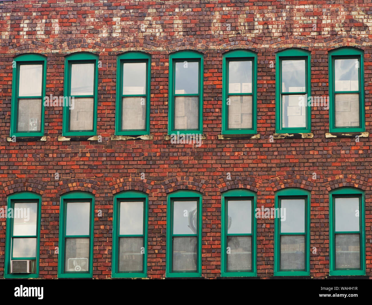 Windows a mattoni vecchi ricambi auto magazzino con foderine segno dipinto. Foto Stock