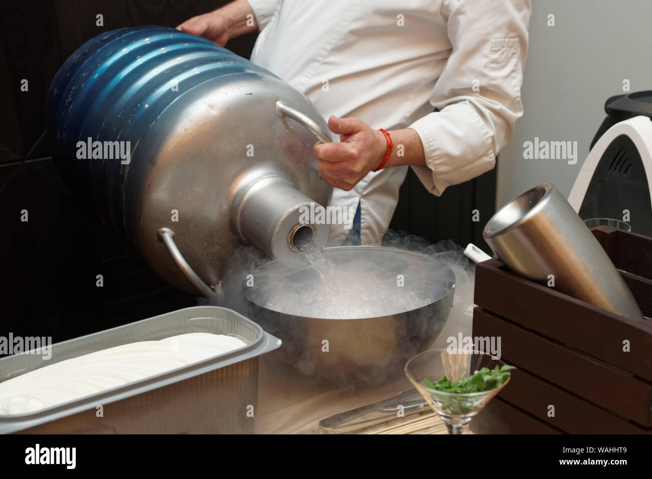Lo chef è colata di azoto liquido da un grande contenitore Dewar Foto Stock