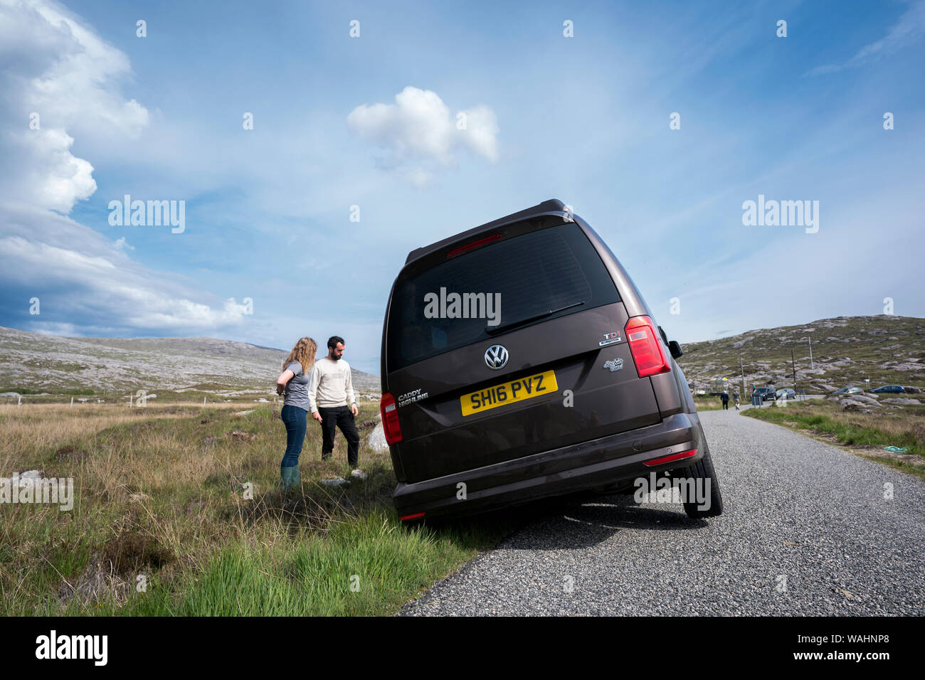 I turisti di analizzare la situazione dopo la loro auto a noleggio è andato fuori una stretta strada in Harris, isola di Lewis, Ebridi Esterne, Scotland, Regno Unito Foto Stock