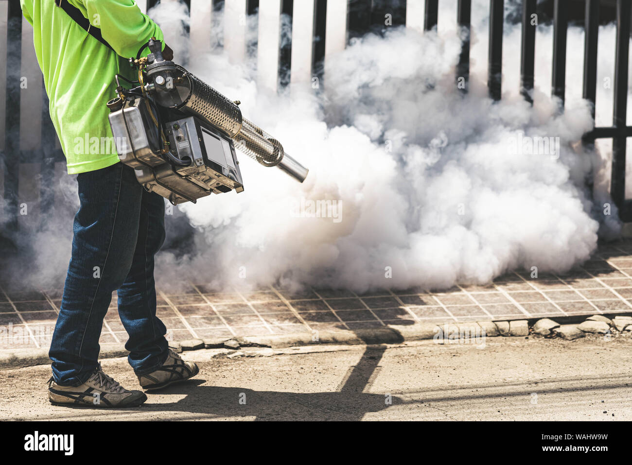 Uomo che utilizza fogger macchina a controllo da pericolose zanzare Foto Stock