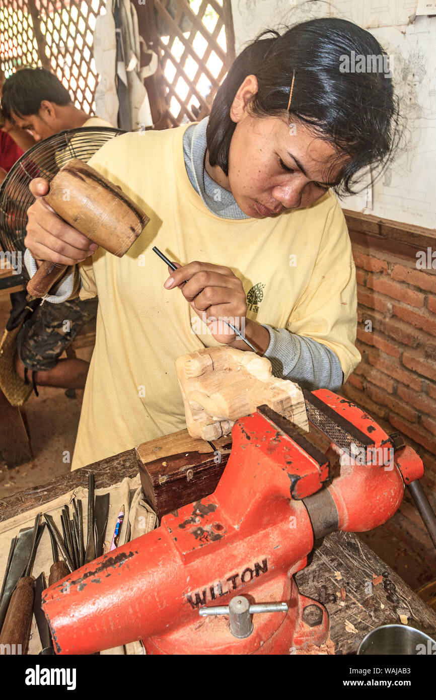 Siem Reap, Cambogia. Giovane donna carving una figura al di fuori del bosco di artigiani Angkor, un workshop che i treni giovani ignoranti e disabili giovani cambogiani nell'artigianato. (Solo uso editoriale) Foto Stock