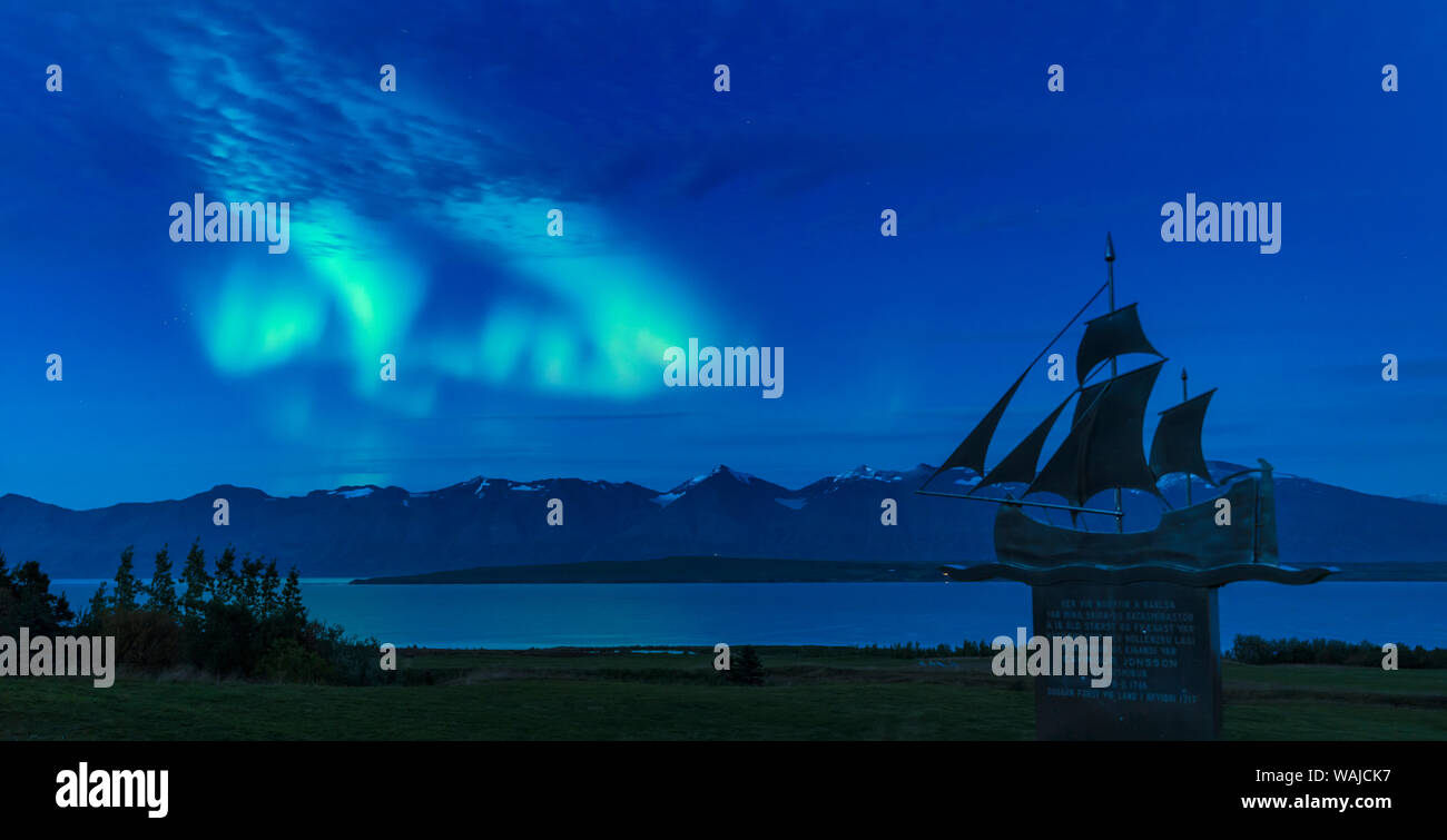 Luci del nord oltre Eyjafjordur vicino Dalvik in Islanda. Monumento commemorativo di nave builder Eyvindur Jonsson. Foto Stock