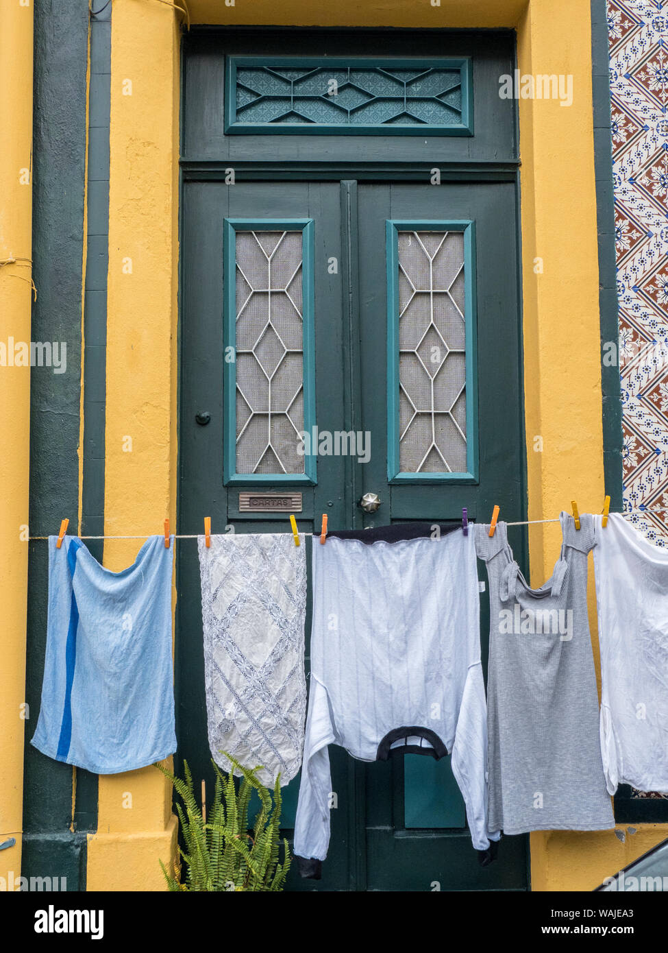 L'Europa, Portogallo Aveiro. Servizio lavanderia appeso attraverso la parte frontale di una porta in strada. Foto Stock