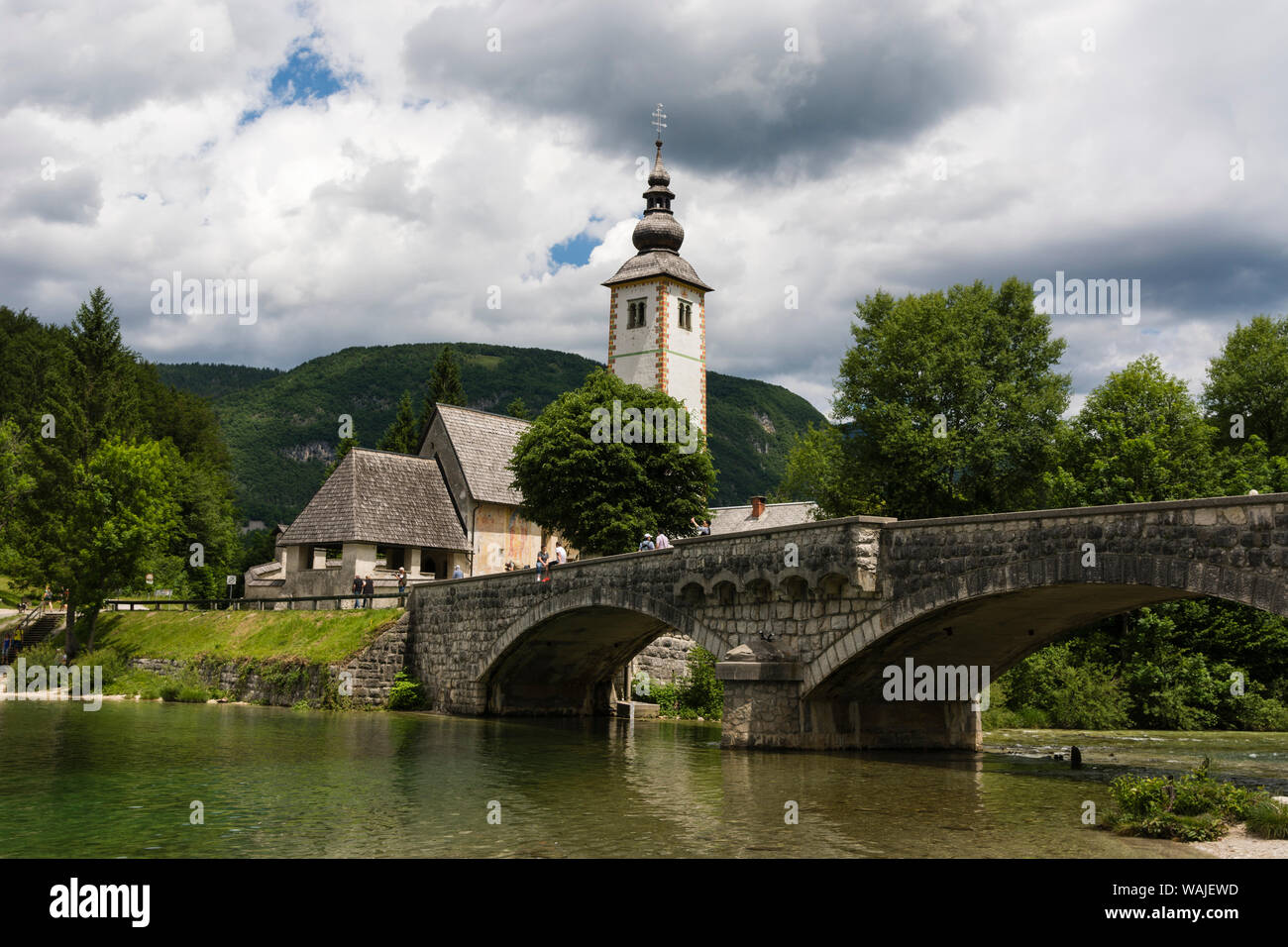 Chiesa di San Giovanni Battista e il ponte di pietra sul lago di Bohinj, Slovenia. Foto Stock