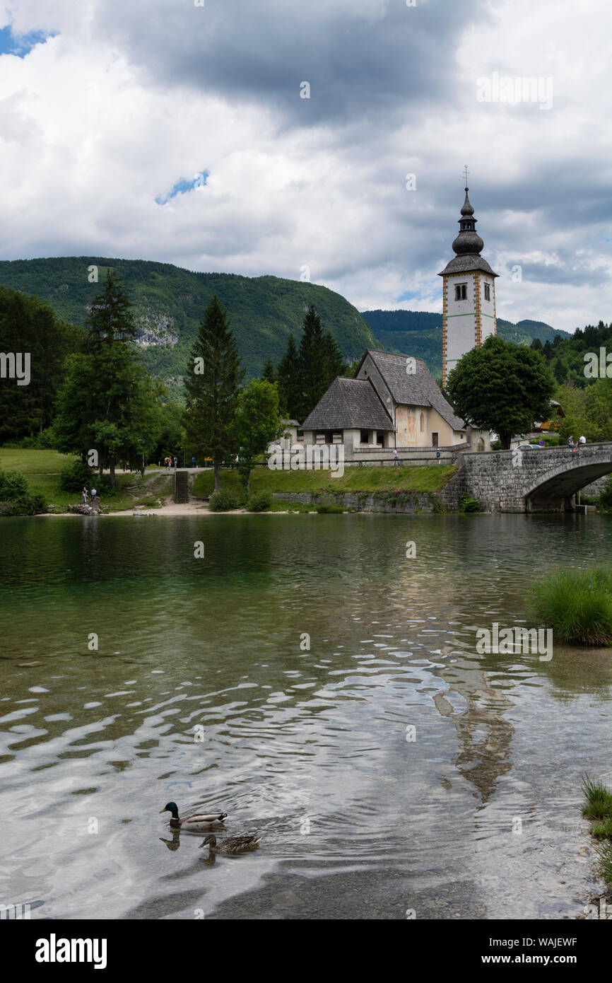 Chiesa di San Giovanni Battista e il ponte di pietra sul lago di Bohinj, Slovenia. Foto Stock