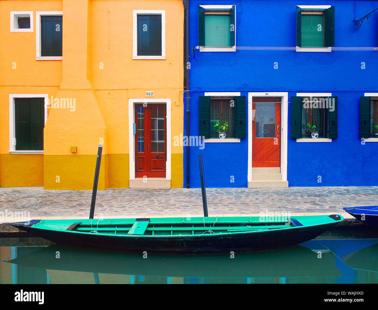 L'Italia, Burano. Casa colorati esterni e barca nel canale. Credito come: Jim Nilsen Jaynes / Galleria / DanitaDelimont.com Foto Stock