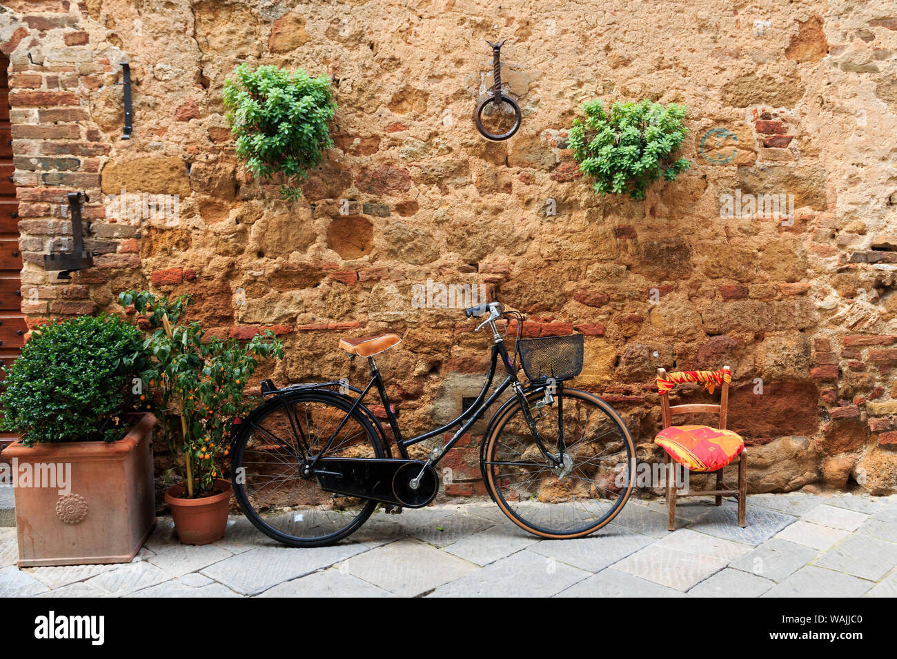 L'Italia, in Toscana, in provincia di Siena, chiusure. Città sulla collina. Noleggio appoggia contro il muro di pietra. Foto Stock