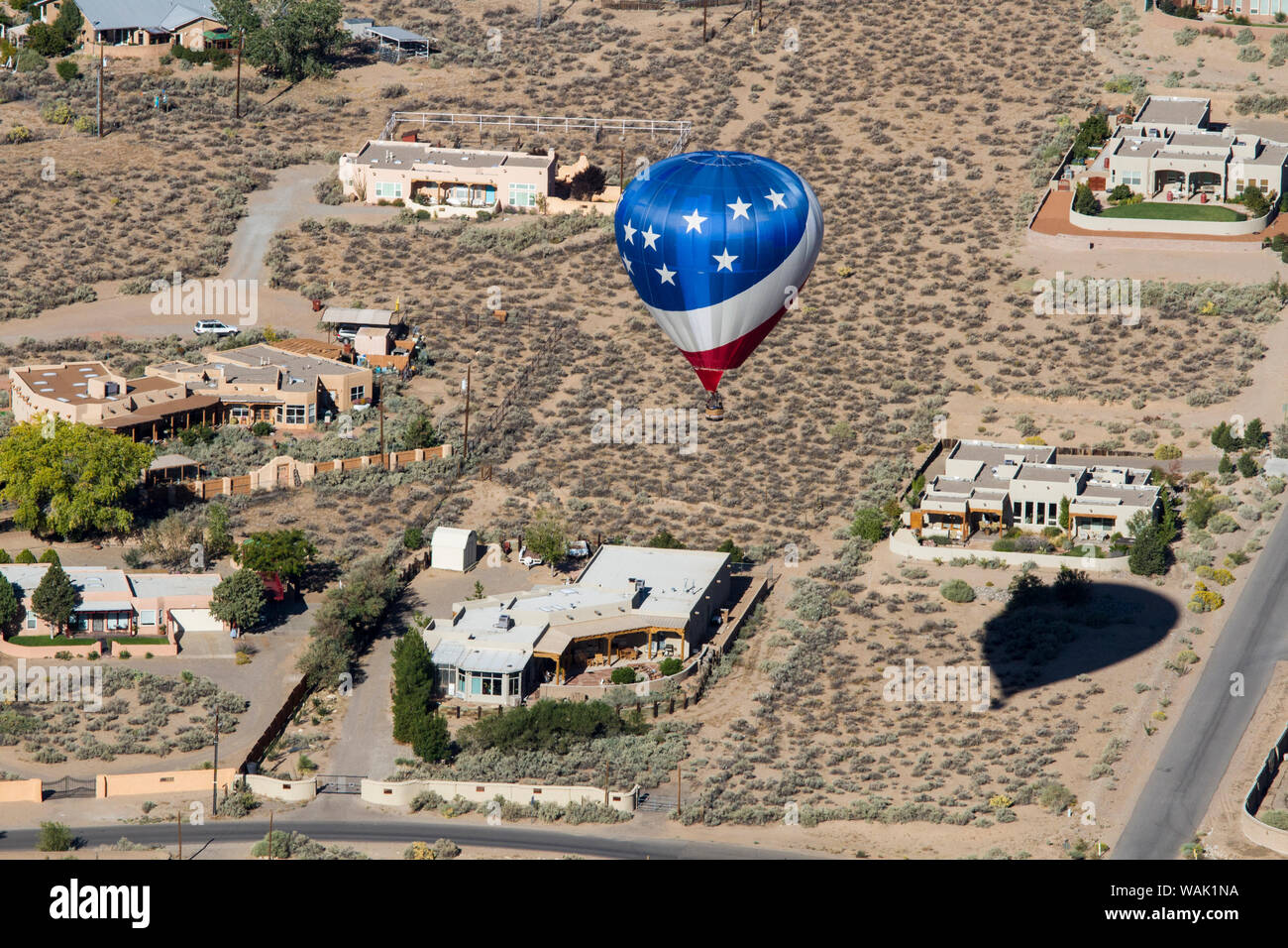 Stati Uniti d'America, Nuovo Messico. Un rosso, bianco e blu a palloncino floating in case in Albuquerque come parte della International Balloon Fiesta. Foto Stock