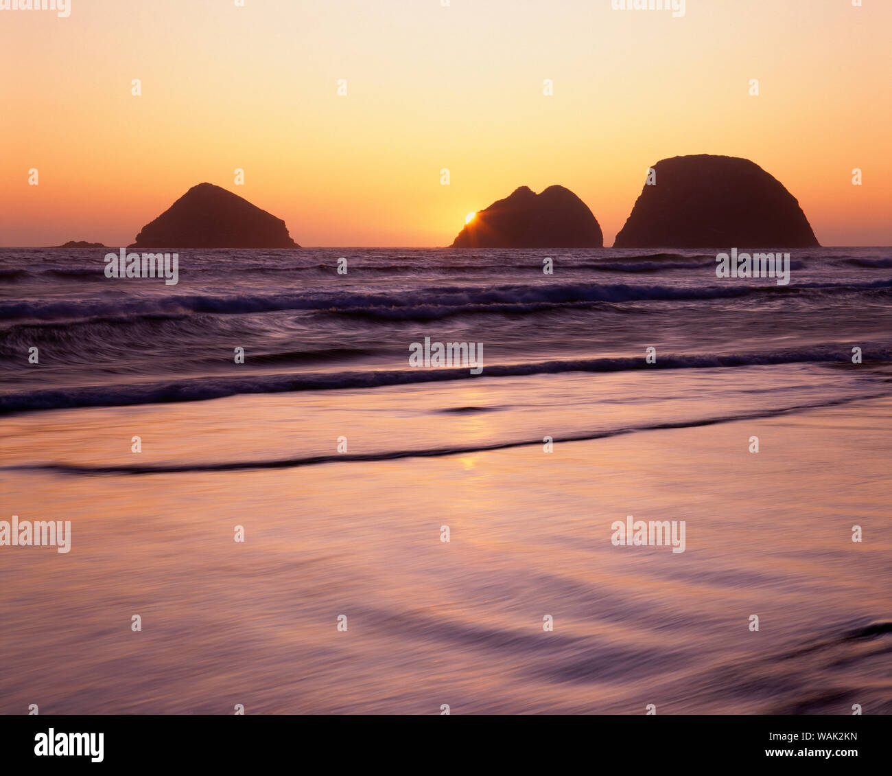 Stati Uniti d'America, Oregon, Oceanside Beach stato perso. Tramonto su tre Arch rocce. Foto Stock