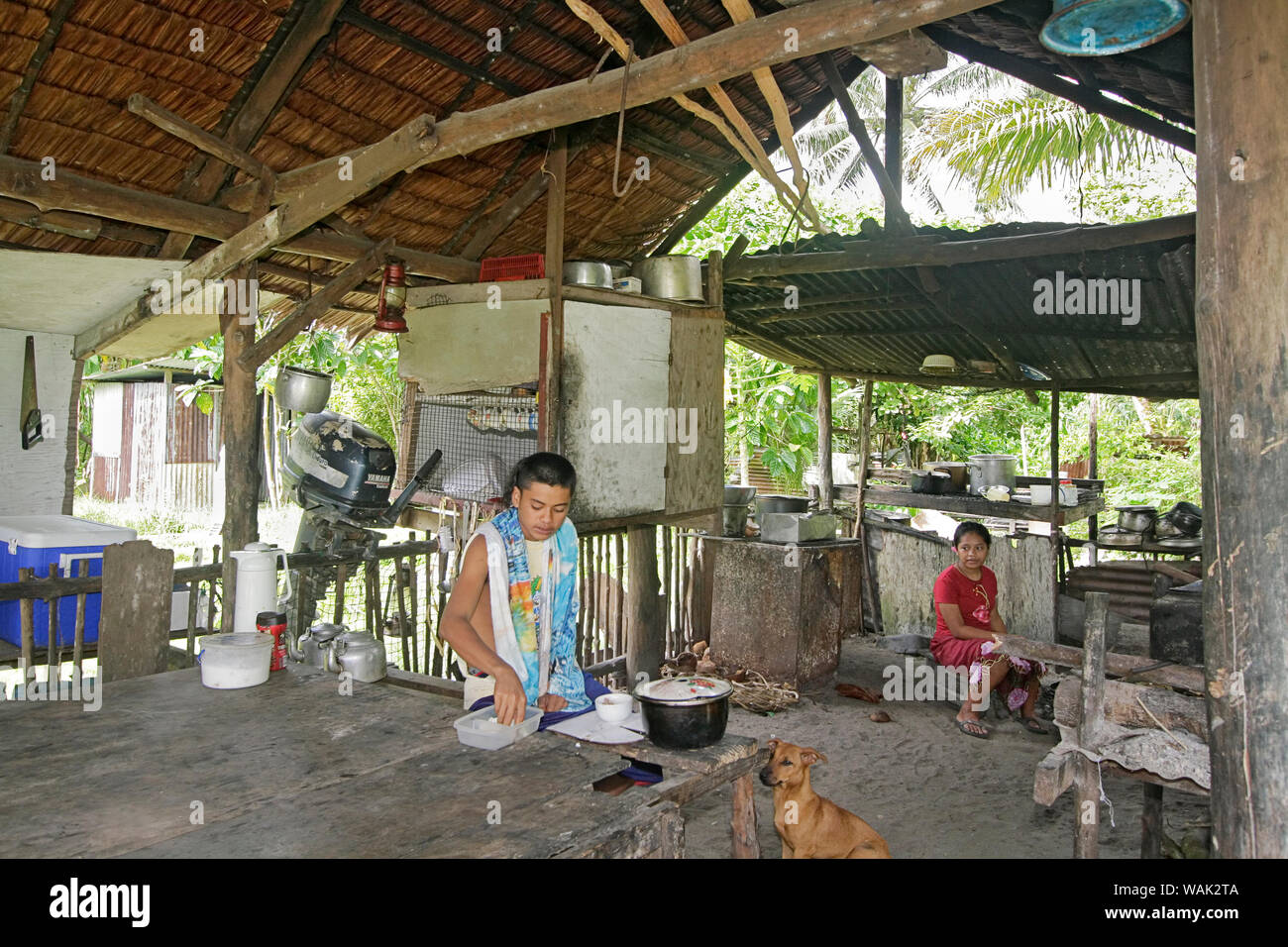 Kosrae, Stati Federati di Micronesia (FSM). Giovane uomo cucinare la cena nella capanna di cucina, di solito una struttura aperta con stagno o paglia di palma e il pavimento sporco. (Solo uso editoriale) Foto Stock