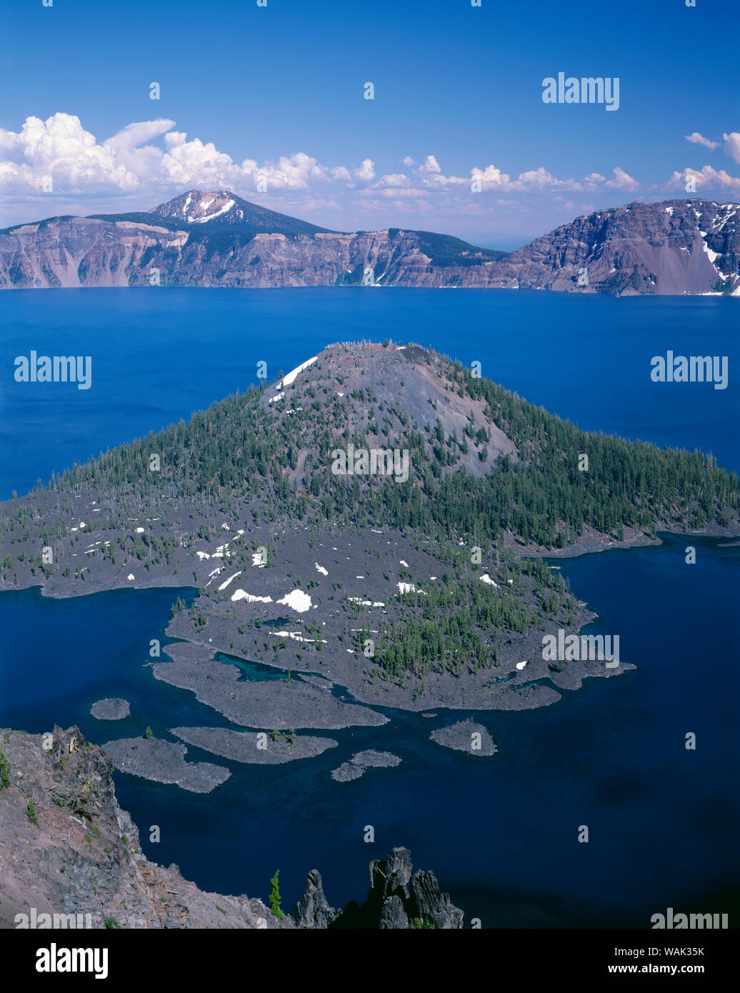 Stati Uniti d'America, Oregon, il Parco nazionale di Crater Lake. Vista est attraverso il cratere del lago da direttamente Sopra Wizard Island con distante Monte Scott e nuvole di tuono. Foto Stock