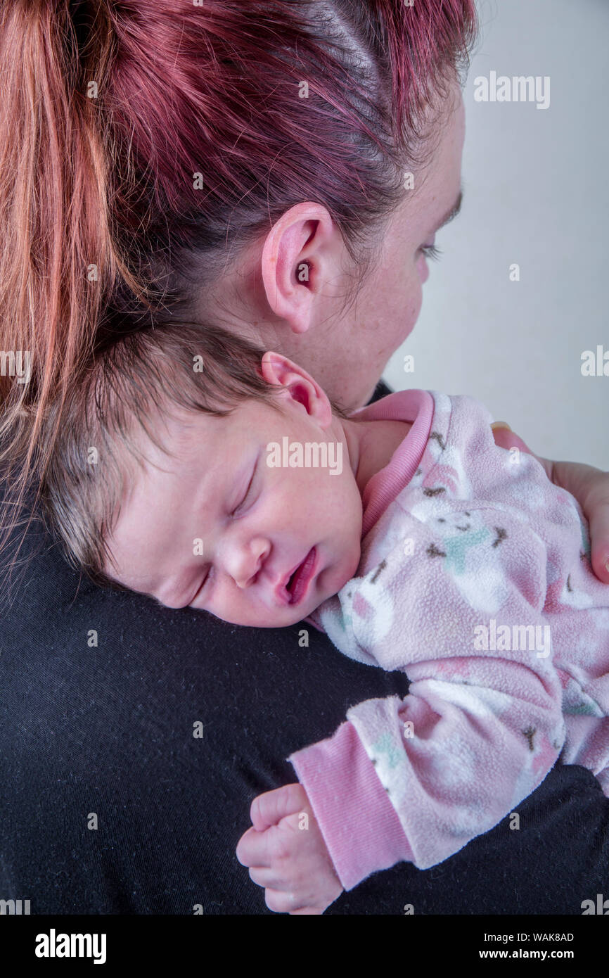 Madre teneramente holding suo sonno dodici giorni di età bambina. (MR) Foto Stock