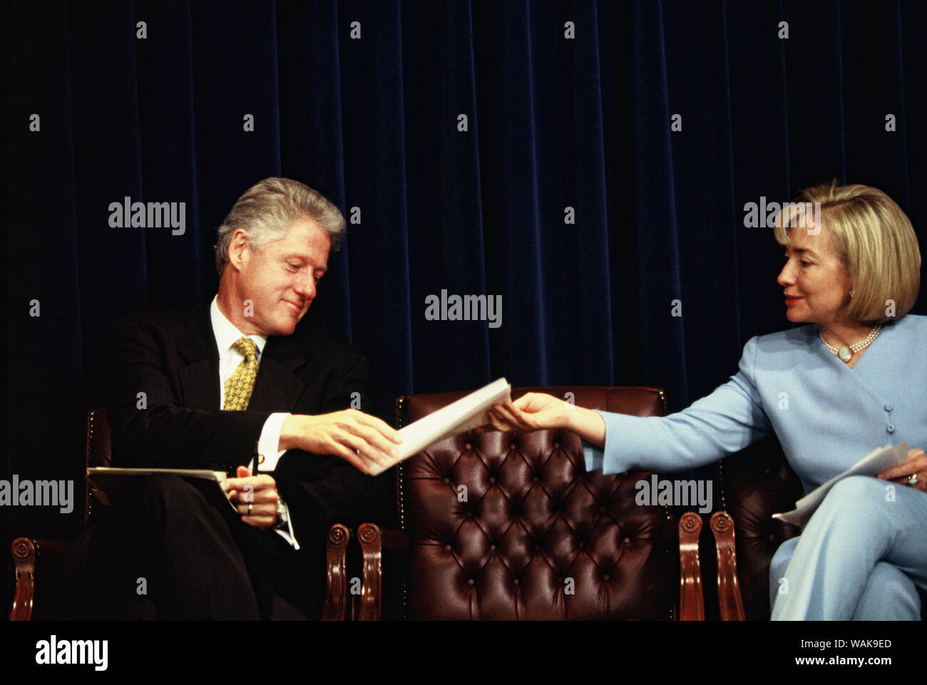 Agosto 13, 1997. Washington, D.C. Il presidente William Jefferson Clinton e la First Lady Hillary Rodham Clinton passare una nota durante una cura di salute evento. Foto Stock