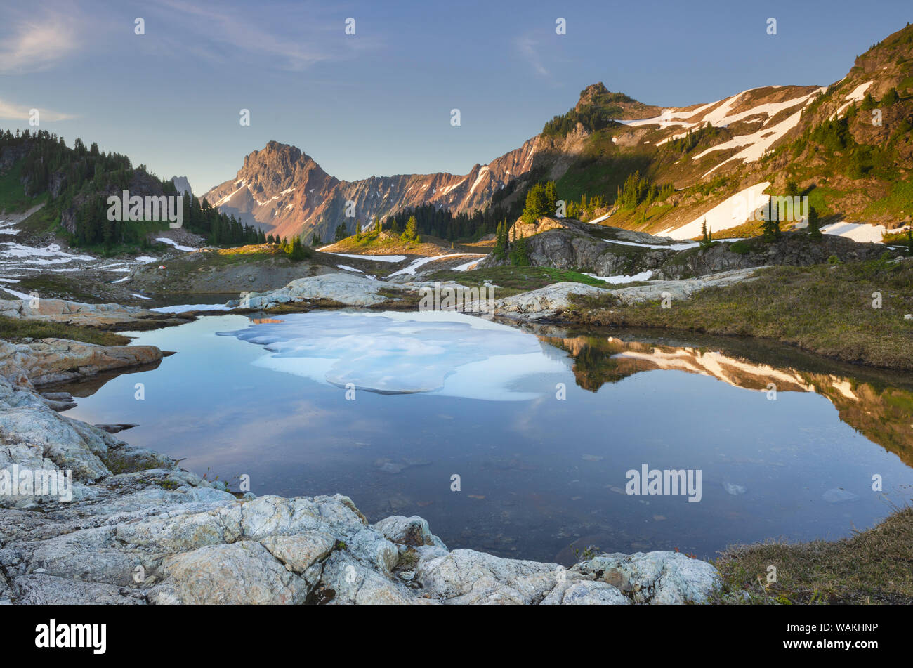 Parzialmente scongelato tarn, giallo Aster Butte bacino. Confine americano picco è nella distanza. Mount Baker deserto, North Cascades, nello Stato di Washington Foto Stock