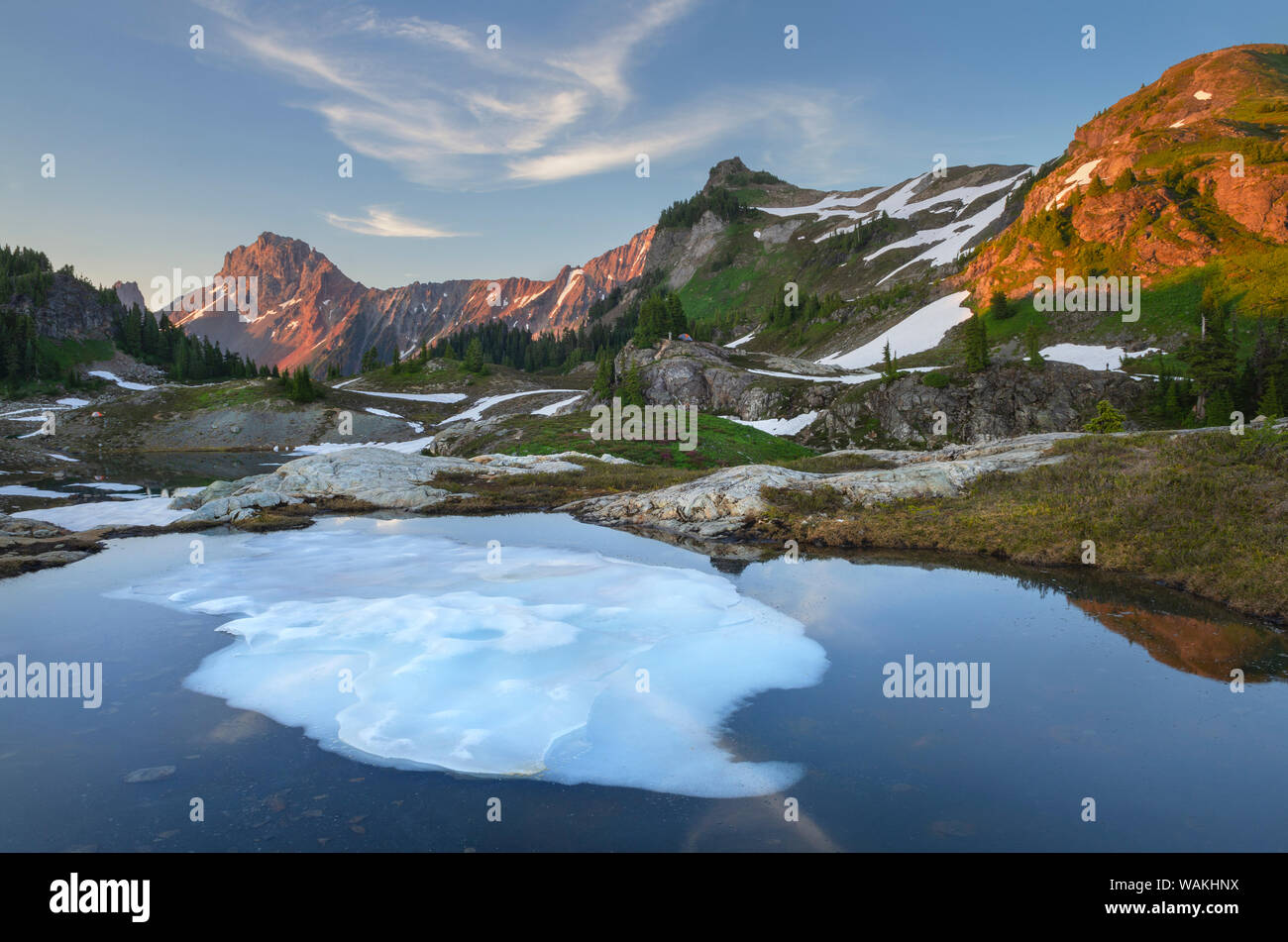 Parzialmente scongelato tarn, giallo Aster Butte bacino. Confine americano di picco e di giallo Aster Butte sono in distanza. Mount Baker deserto, North Cascades, nello Stato di Washington Foto Stock