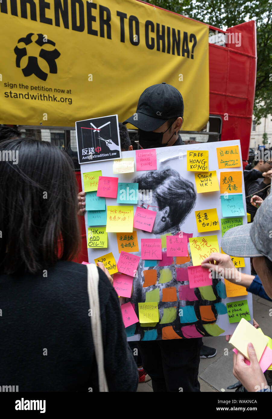 La gente protesta al di fuori dell'Ambasciata cinese a Londra contro la repressione violenta di manifestazioni di protesta in Hong Kong. Con un assunto rossi di Londra autobus Routemaster Foto Stock