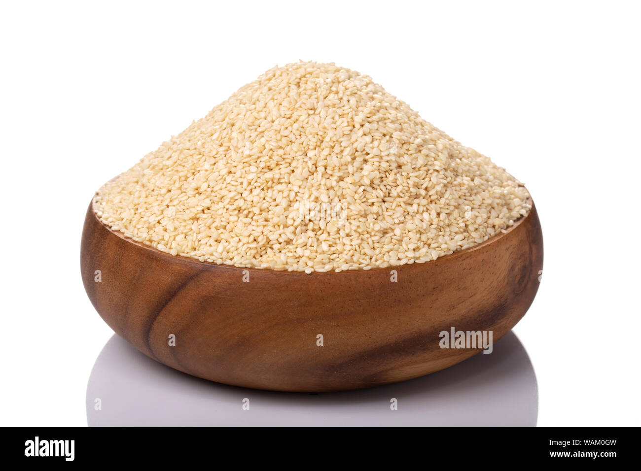 Semi di sesamo bianchi biologici in un recipiente di legno, perfetti per cucinare, cuocere e guarnire. Foto Stock