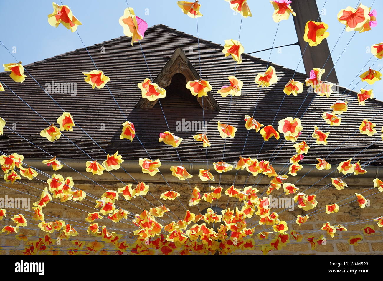 Appendere la festa del villaggio di decorazioni di fiori con una casa dietro sul tetto Foto Stock