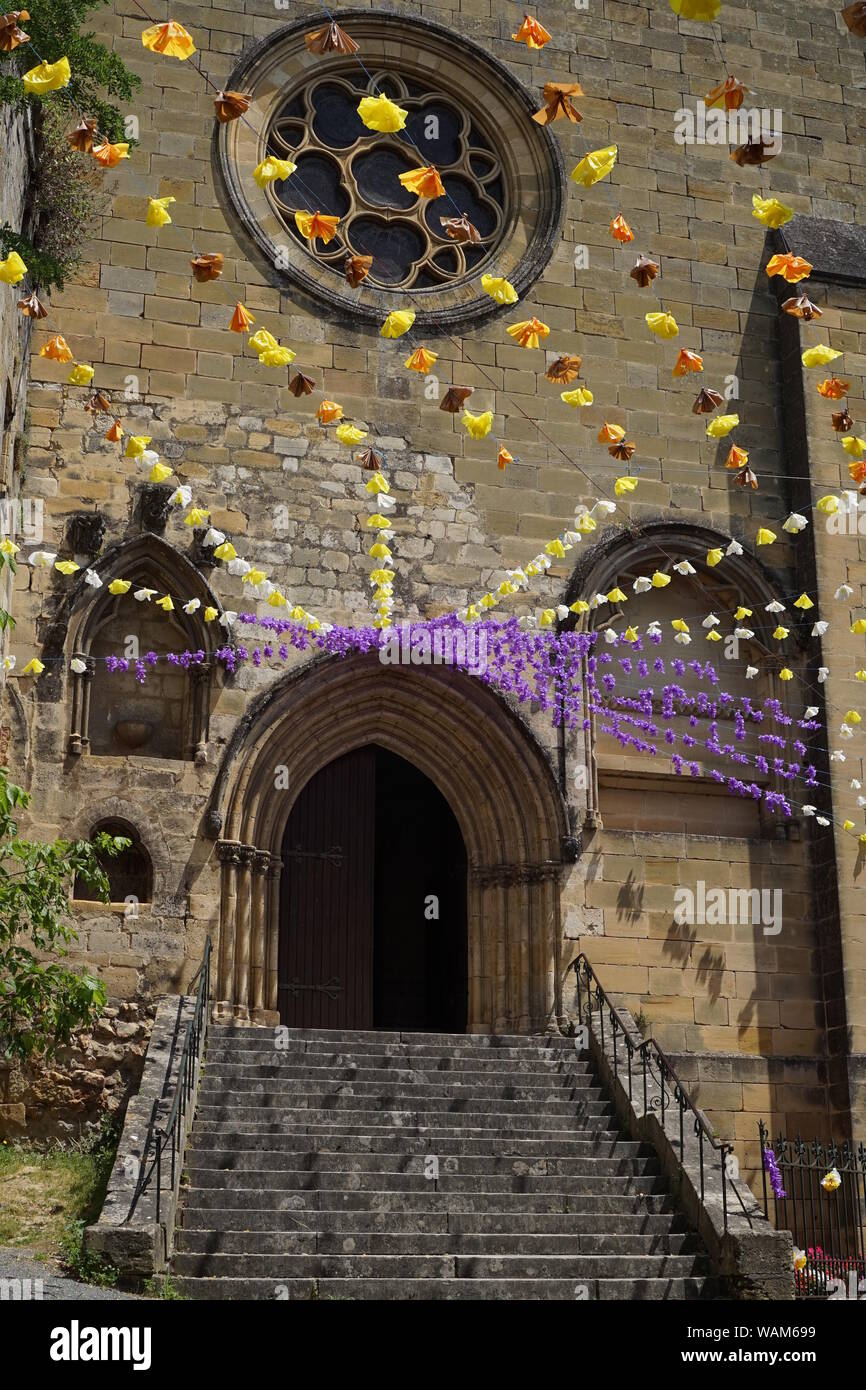 Festival decorazioni pendenti da un villaggio francese chiesa Foto Stock