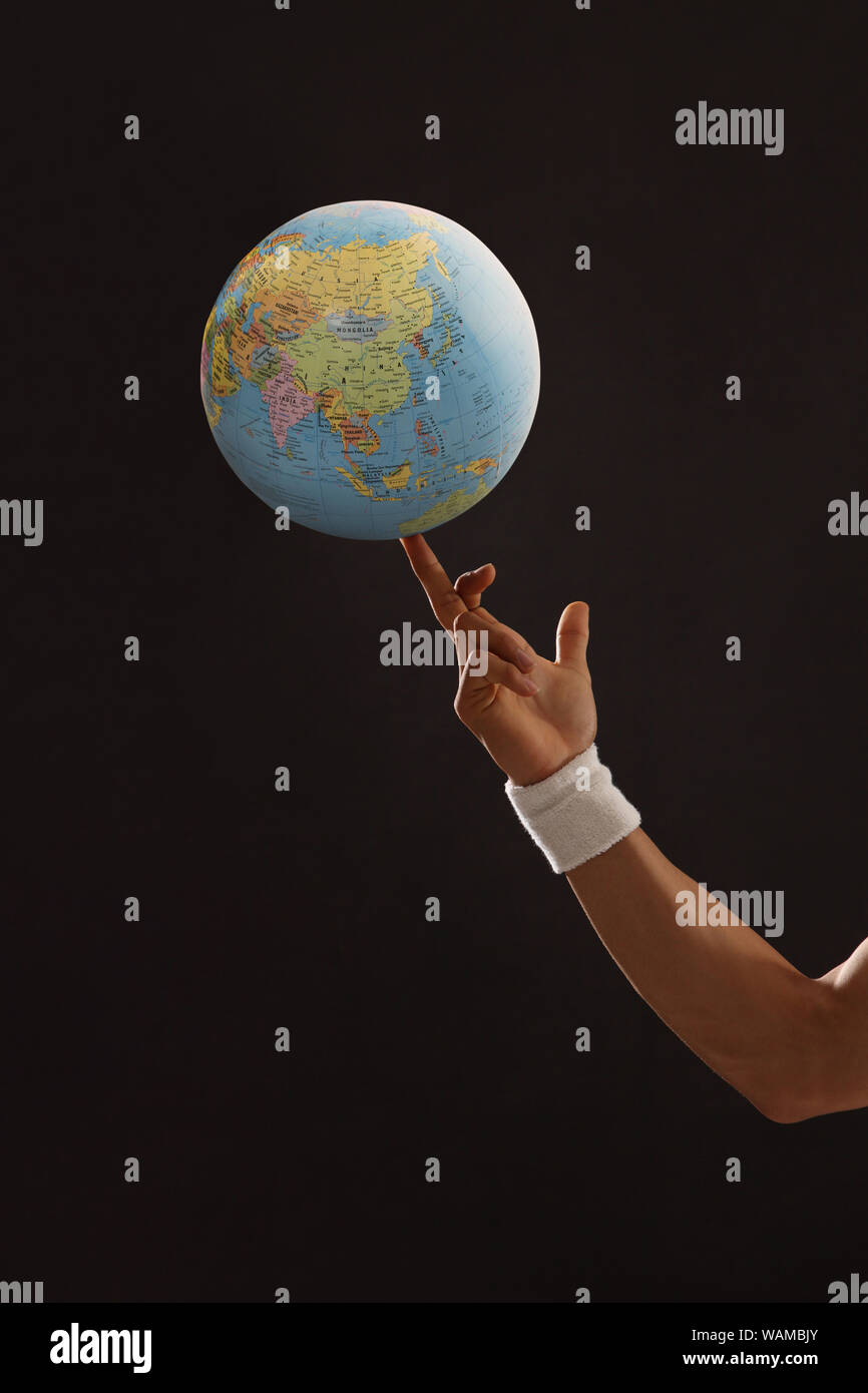 Mondo che gira sull'indice fingertip su sfondo colorato Foto Stock