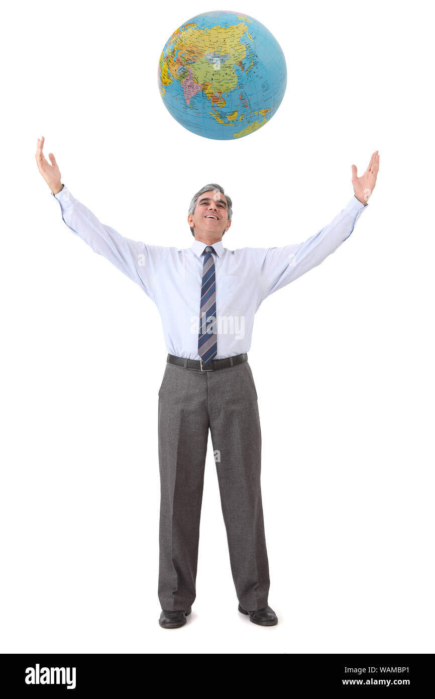 Uomo d'affari in piedi con il suo braccio teso guardando il globo sopra la sua testa Foto Stock