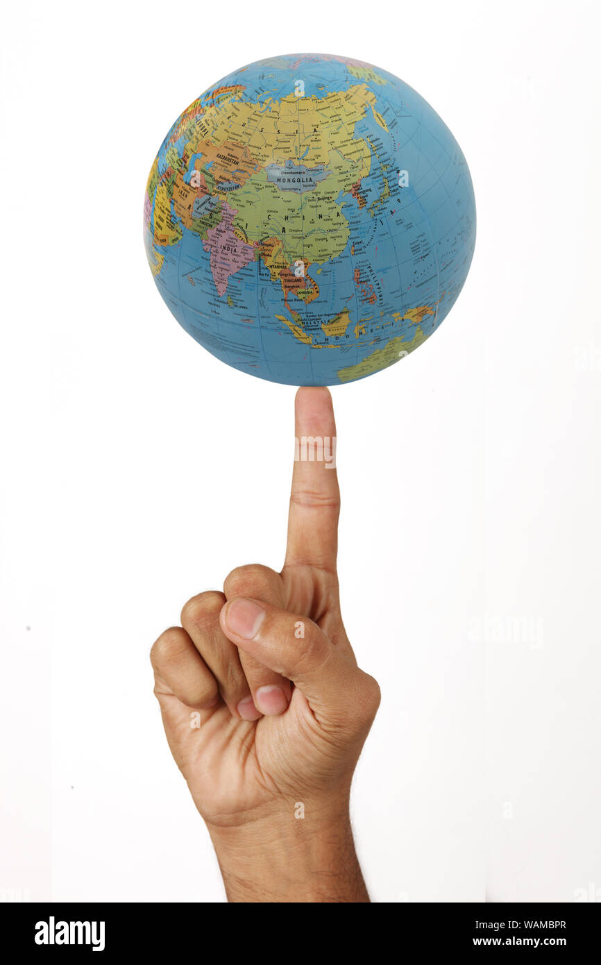Mondo che gira sull'indice fingertip su sfondo bianco Foto Stock