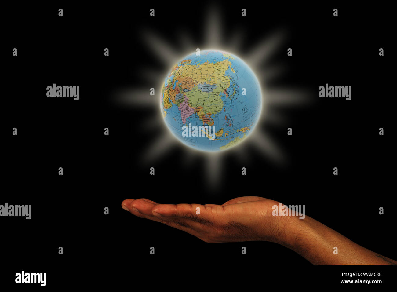 Globo illuminato sopra la mano Foto Stock