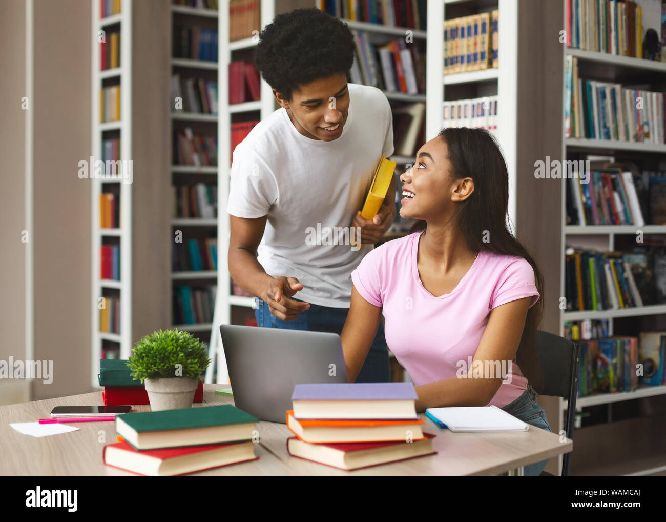 Ragazzo nero offrendo supporto alla ragazza afro in libreria Foto Stock