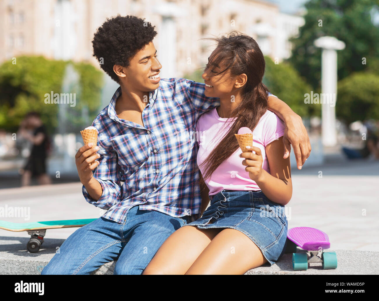 Coppia felice a mangiare il gelato in strada Foto Stock