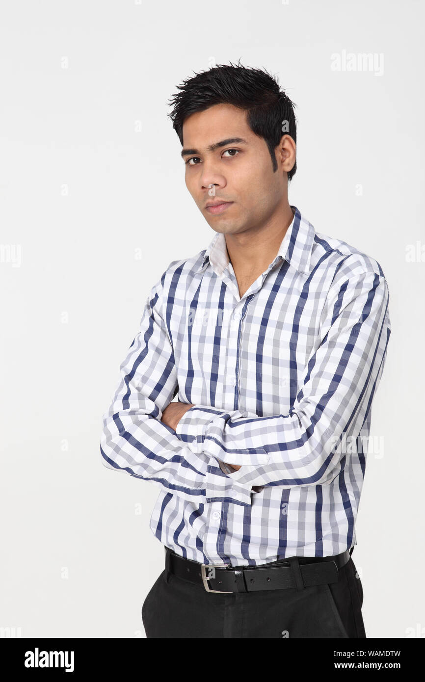 Giovane uomo in piedi con le braccia incrociate Foto Stock