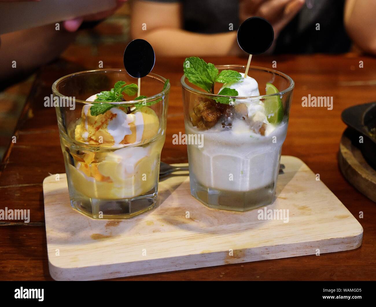 Due bicchiere di gelato su un vassoio in legno , dolce e un sapore rinfrescante dal frutto Durian e latte di cocco decorate di lime e foglie di menta , della Thailandia Foto Stock