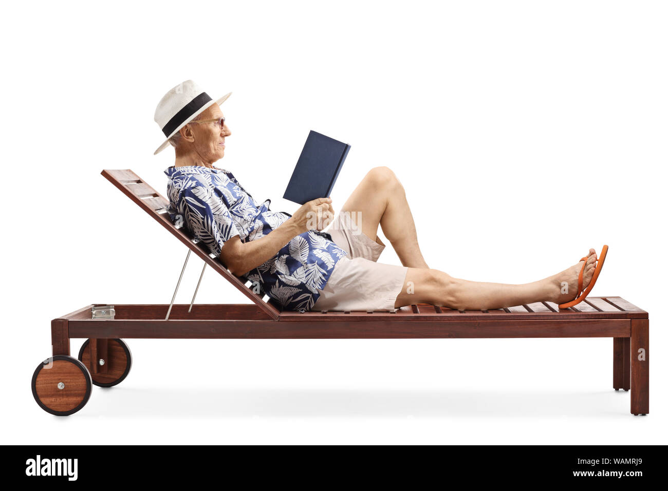 A piena lunghezza shot di un uomo maturo la lettura di un libro su un lettino solare isolato su sfondo bianco Foto Stock