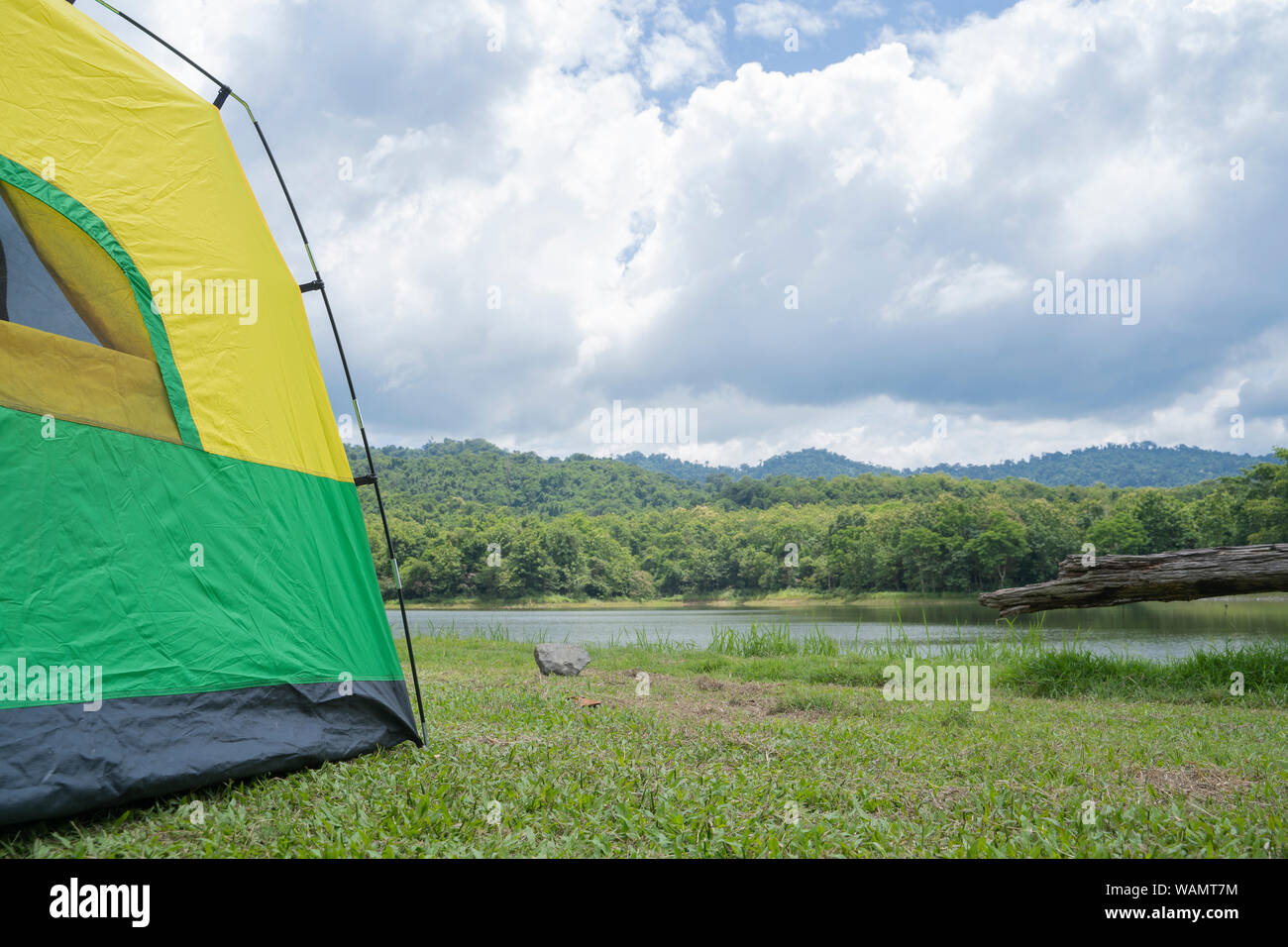 Camping verde-giallo tenda nella foresta vicino lago. Foto Stock