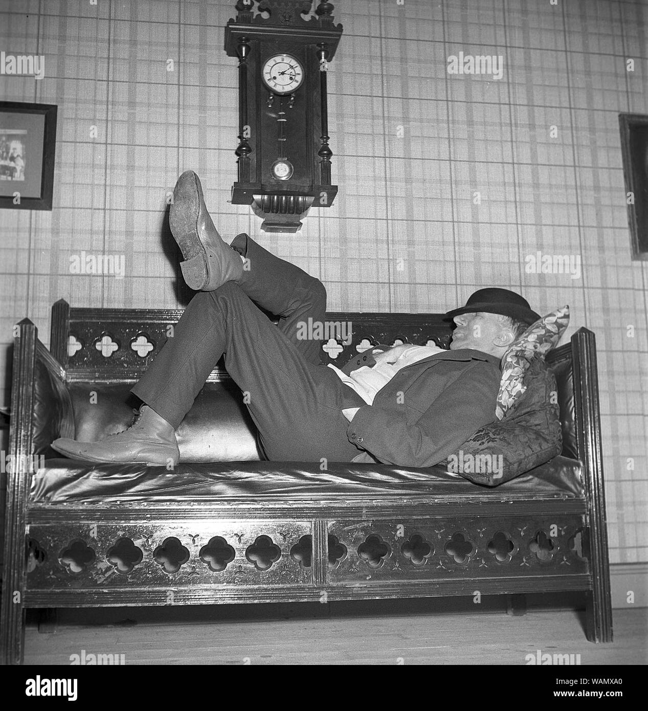 Avendo un pisolino nel 1940s. Un uomo stanco è sdraiato sul divano avente  un pisolino. Egli è attore Ludde Gentzel e stelle nel film Kronblom. La  Svezia 1947. Foto Kristoffersson ref ref