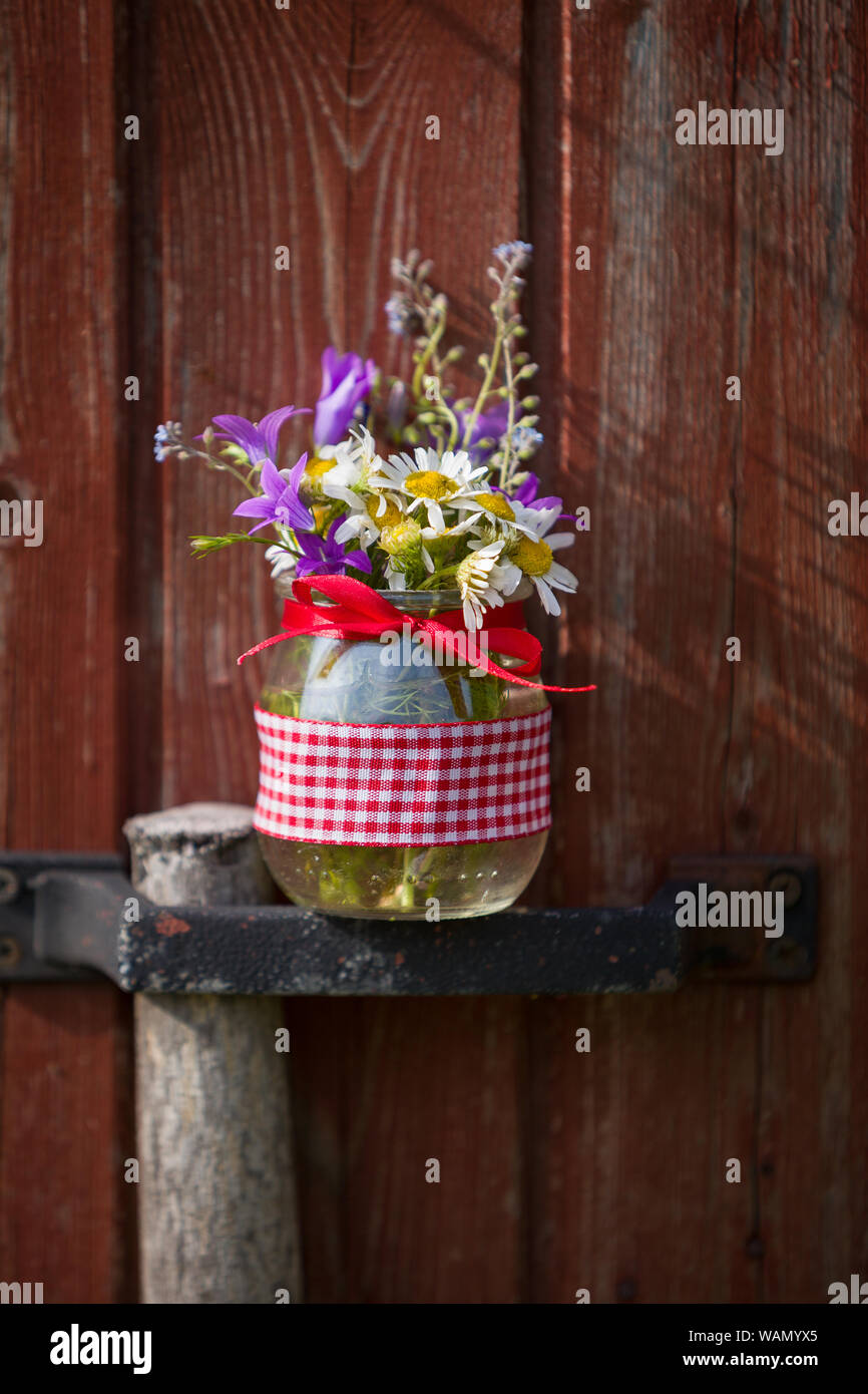 Bella estate fiori selvatici in un bel vaso di vetro su uno sfondo di legno. Estate bouquet. Mazzo di fiori. L'estate. Presente. Foto Stock