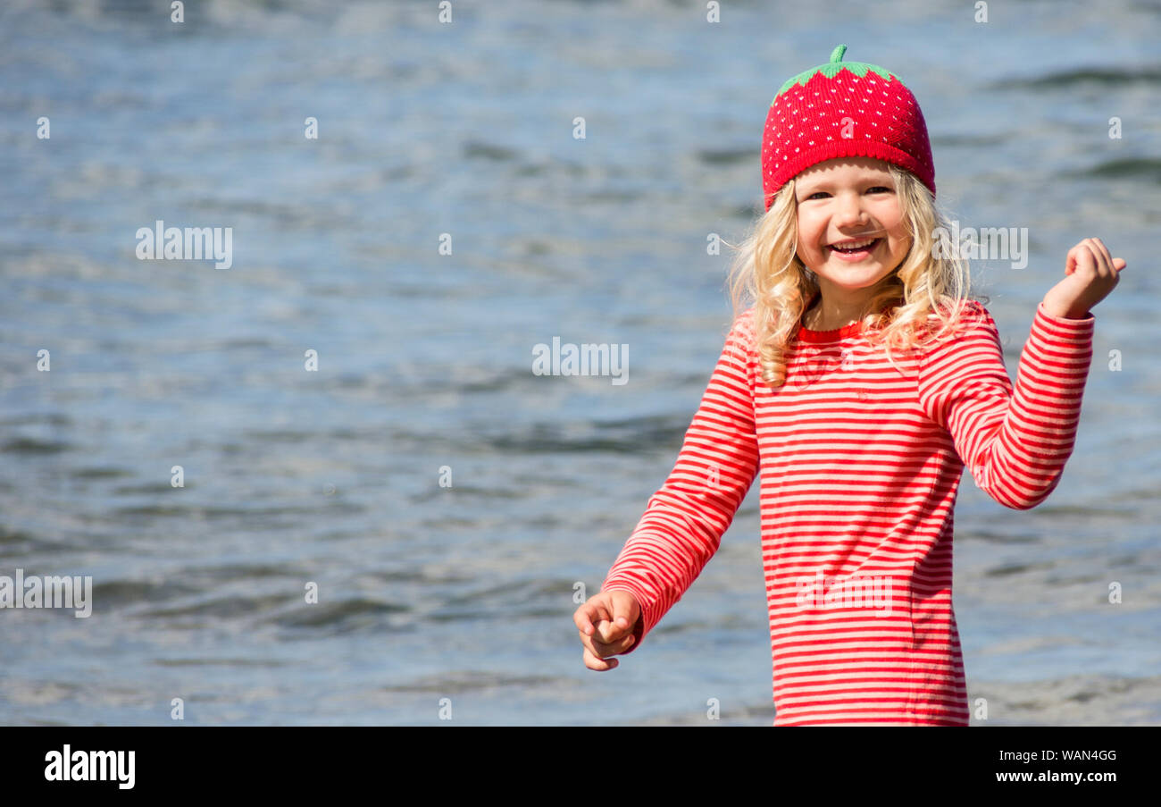 Mädchen mit Erdbeermütze am Strand 1 Foto Stock