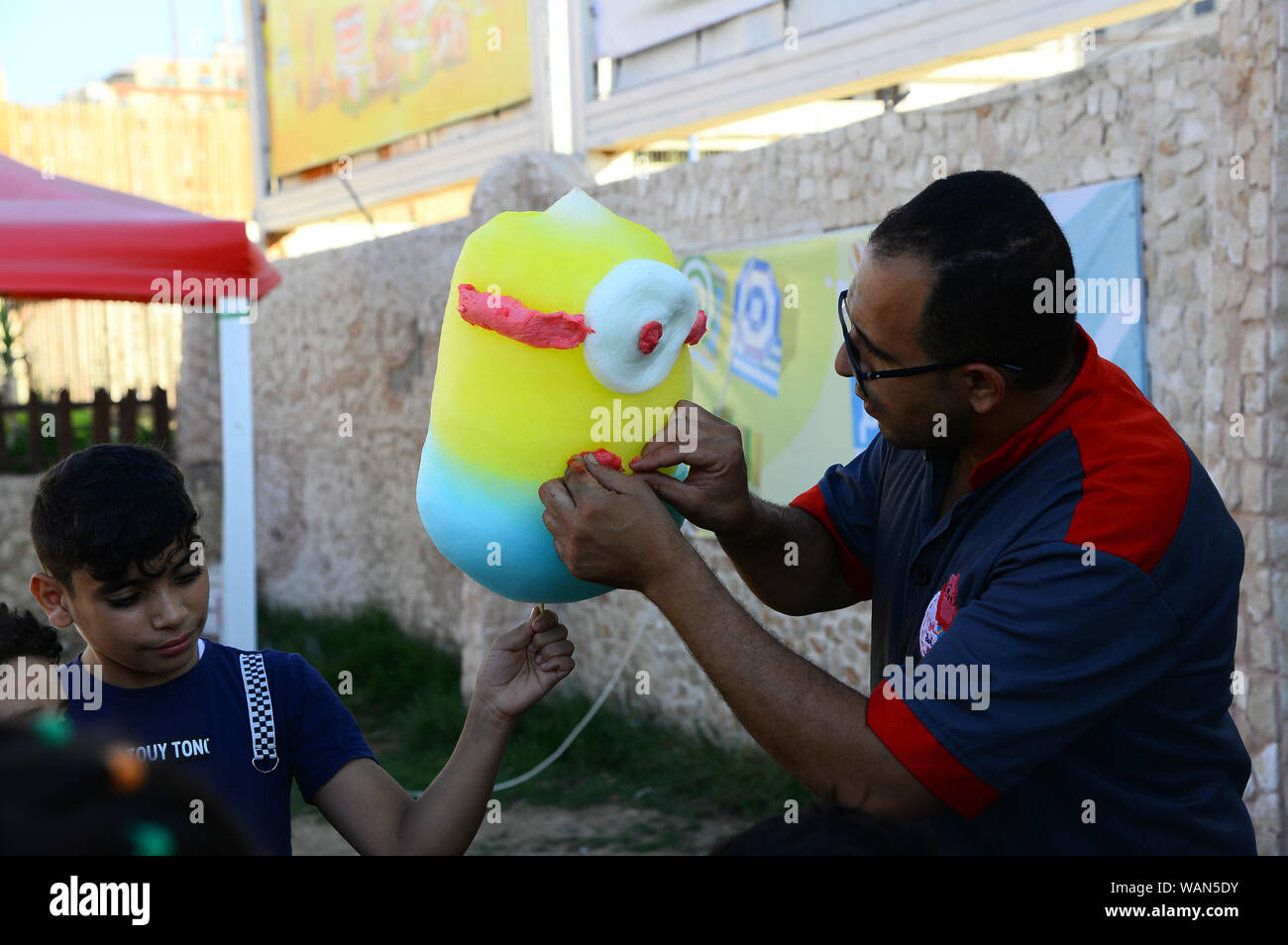 (190821) -- GAZA, Agosto 21, 2019 (Xinhua) -- Mohammed al-Wakeel, un 33-anno-vecchio palestinese che è buona a progettare il cotone caramelle in varie forme e colori, rende la caramella di cotone in un parco nella città di Gaza, 19 Agosto, 2019. (Str/Xinhua) Foto Stock