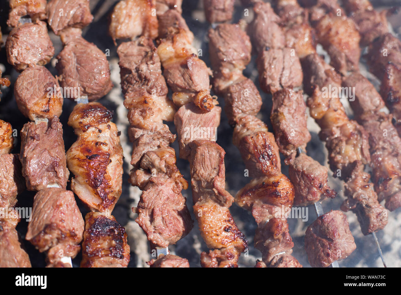 La consistenza della carne arrosto. Stuzzicante di tagli di carne su spiedini. Agnello alla griglia, molto gustoso cibo. Sfondo Kebab Foto Stock