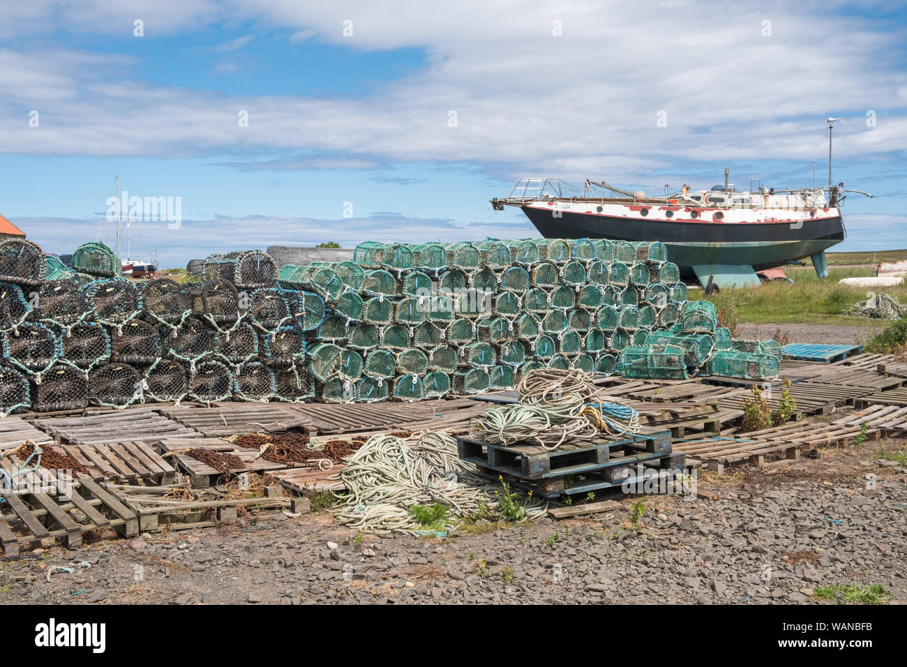 Fishermens' aragosta e granchio pentole in ordinate cataste sul Santo Isola di Lindisfarne in Northumberland, Regno Unito Foto Stock