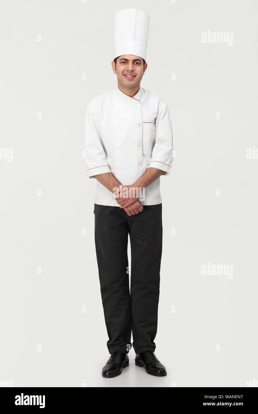 Chef in piedi con le mani aggrappate Foto Stock