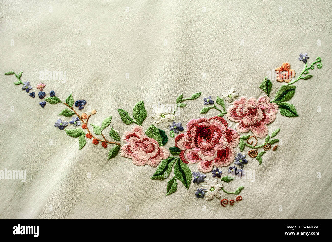 Ricamo a punto raso rosa rose con altri fiori e foglie su un panno di  cotone Foto stock - Alamy