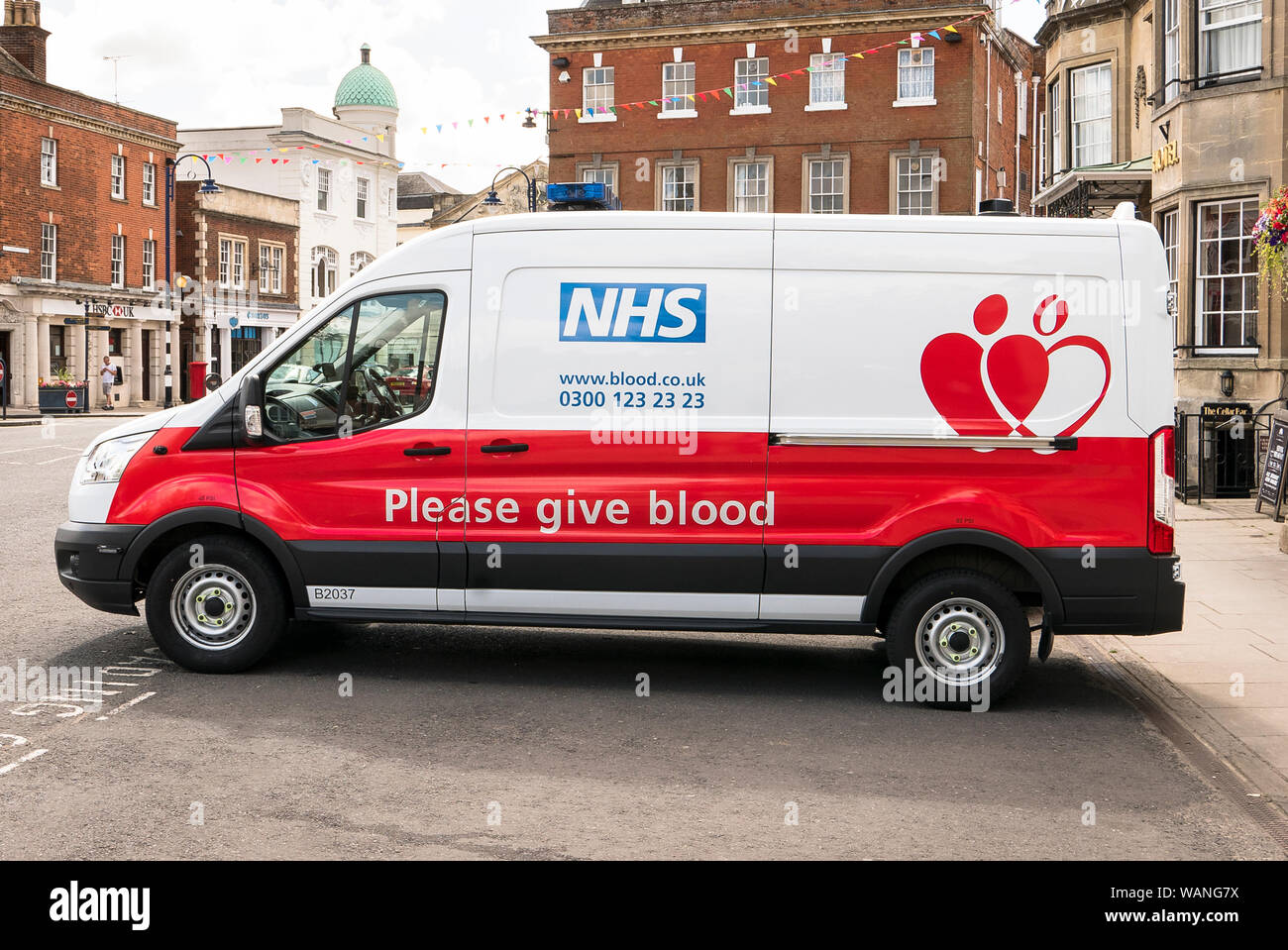 Si prega di dare il sangue è il messaggio sul lato di un NHS van al di fuori di una temporanea per la donazione del sangue centro in Devizes Wiltshire, Inghilterra REGNO UNITO Foto Stock