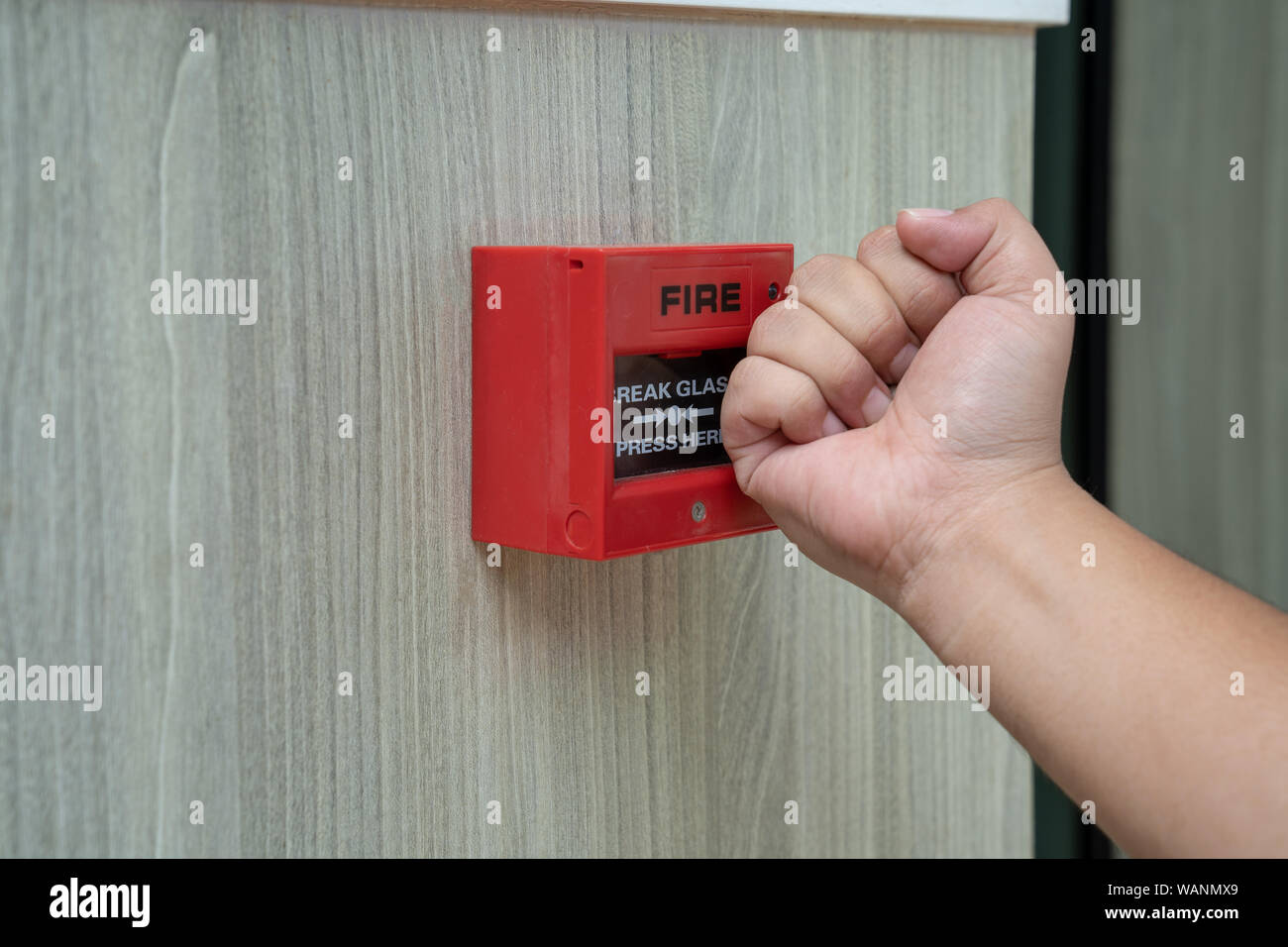 Allarme incendio box con mano umana azione per frantumare il vetro per la situazione di emergenza. Foto Stock