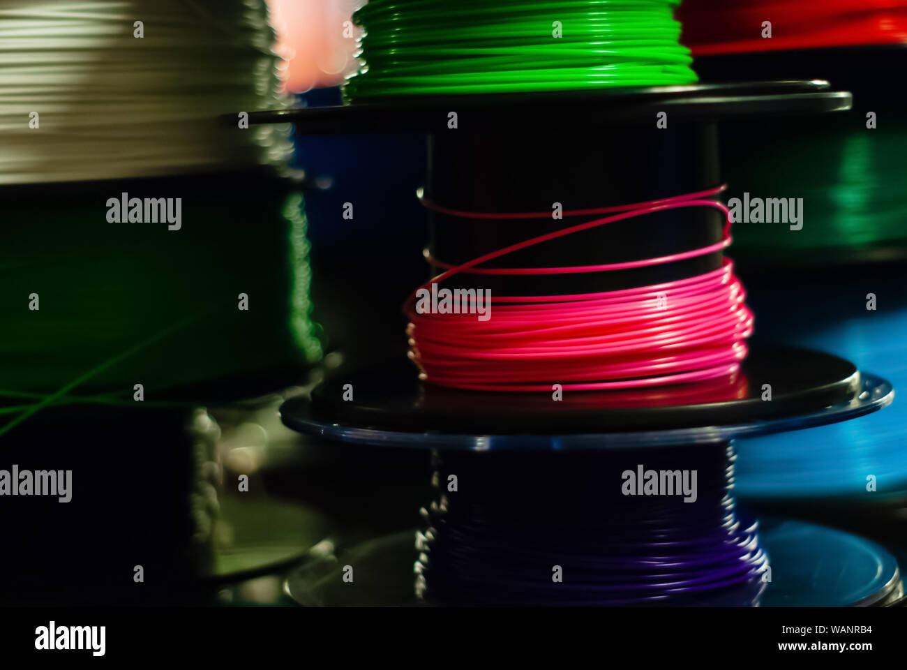 Parzialmente sfocato sfondo scuro - spole di multi-colore filo termoplastico per 3d penne Foto Stock Parzialmente sfocato sfondo scuro - spole di multi-colore filo termoplastico per 3d penne Foto Stock